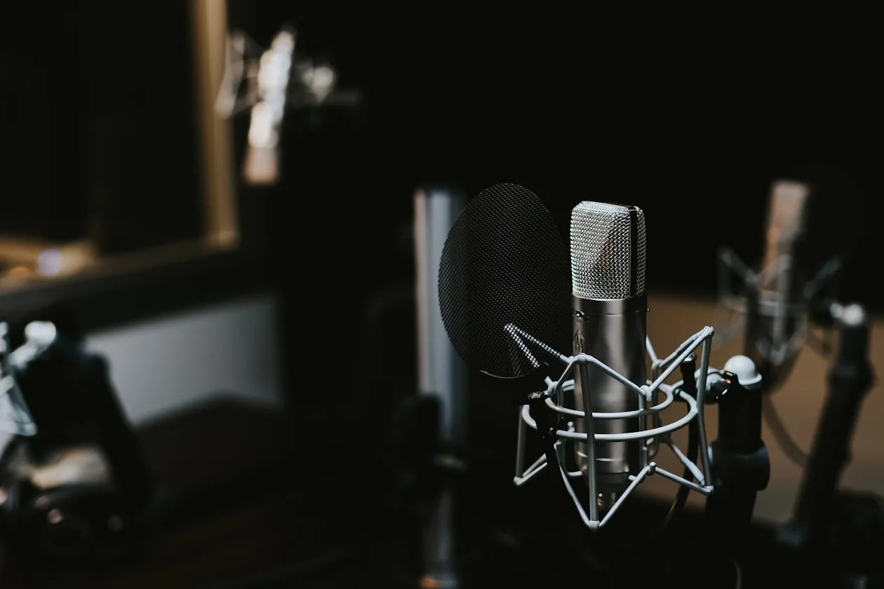 Mand optager podcast med mikrofon og hovedtelefoner i studie